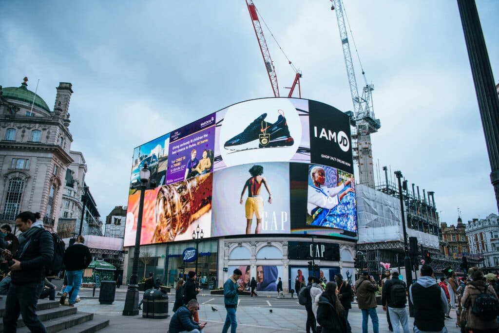Immense écran publicitaire numérique à Piccadilly Circus, Londres, illustrant une campagne DOOH premium (Digital Out Of Home) pour Nike et Gap.